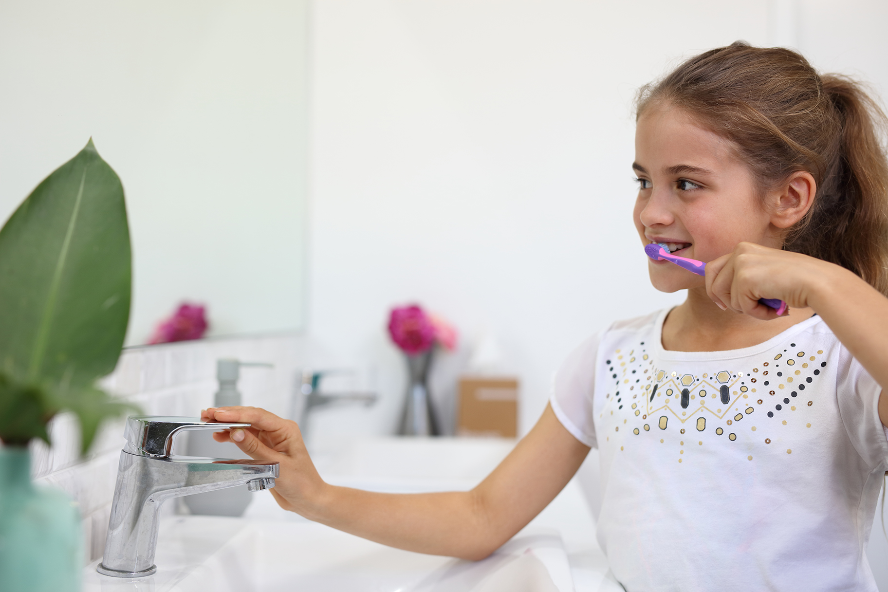 Young girl brushing teeth in bathroom