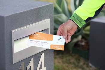 Notice of intent to restrict water supply notice being put into letterbox